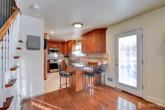 117 Whitman St, Carteret, NJ 07008 - kitchen featuring tasteful backsplash, stainless steel appliances, a kitchen bar, a sink, and visible vents