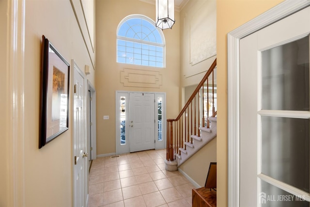 foyer featuring a towering ceiling and light tile patterned floors