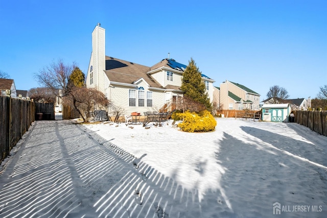 snow covered property featuring a shed