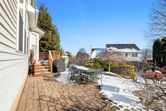 snow covered patio featuring grilling area