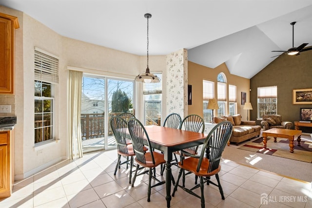 tiled dining area featuring ceiling fan and vaulted ceiling