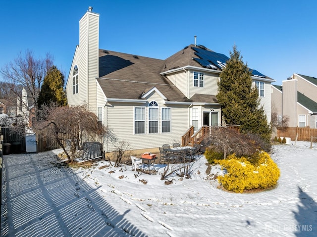 view of snow covered back of property