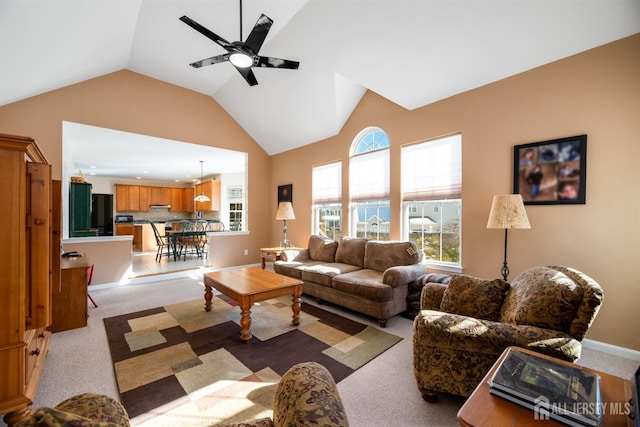 living room featuring ceiling fan, vaulted ceiling, and light carpet