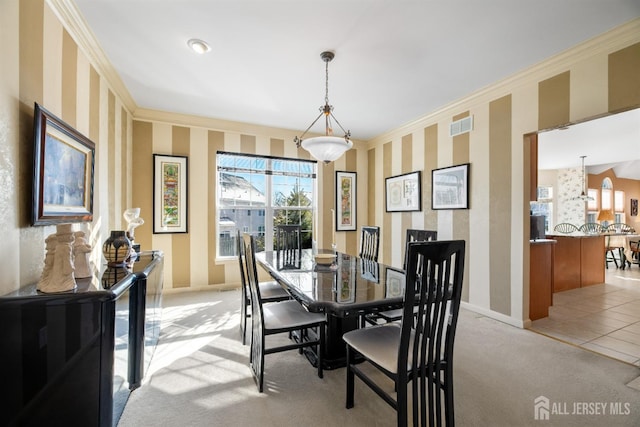 carpeted dining space with ornamental molding