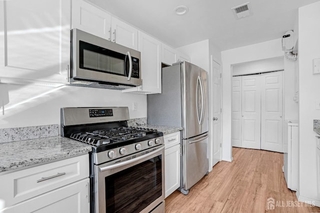 529 Sharon Garden Ct, Woodbridge Proper, NJ 07095 - kitchen with stainless steel appliances, light wood-style flooring, white cabinetry, and light stone countertops
