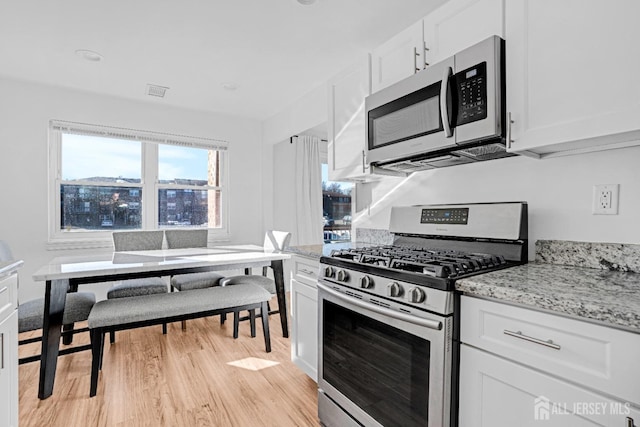 529 Sharon Garden Ct, Woodbridge Proper, NJ 07095 - kitchen featuring stainless steel appliances, light wood-type flooring, white cabinets, and light stone counters