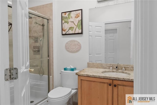 full bathroom with a shower stall, vanity, and toilet