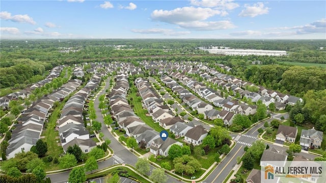 aerial view of property's location featuring nearby suburban area and a forest