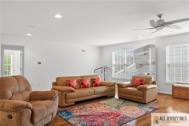 living area with wood finished floors, a ceiling fan, recessed lighting, and baseboards