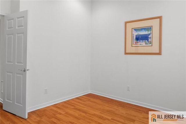 empty room featuring light wood-style flooring and baseboards