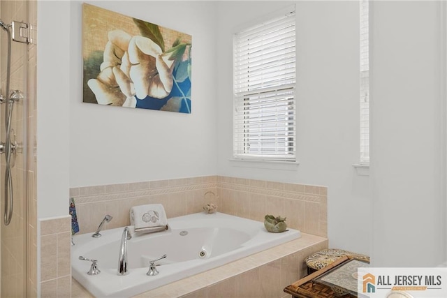 bathroom featuring a stall shower and a tub with jets