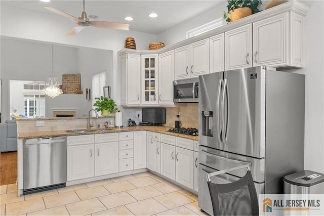 kitchen with appliances with stainless steel finishes, a sink, plenty of natural light, a peninsula, and recessed lighting