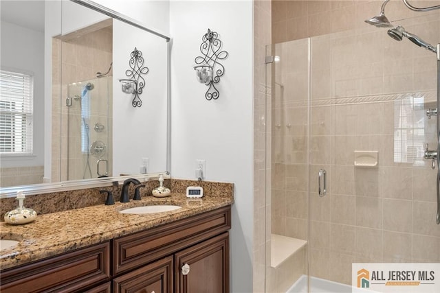 bathroom with a stall shower and double vanity