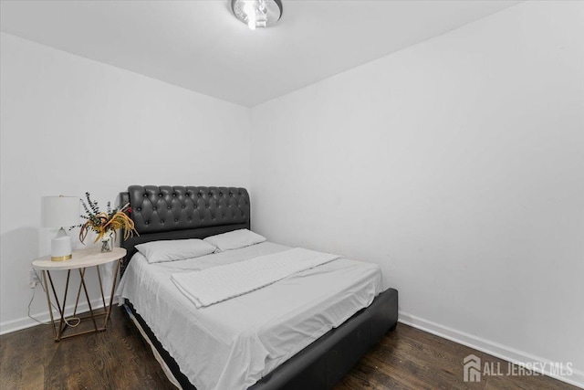 bedroom with baseboards and wood finished floors