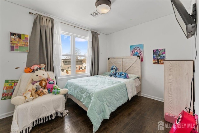 bedroom featuring baseboards, visible vents, and wood finished floors