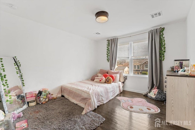 bedroom featuring baseboards, visible vents, and wood finished floors
