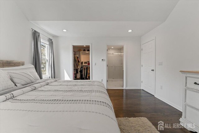 bedroom with recessed lighting, baseboards, dark wood-style floors, and a spacious closet