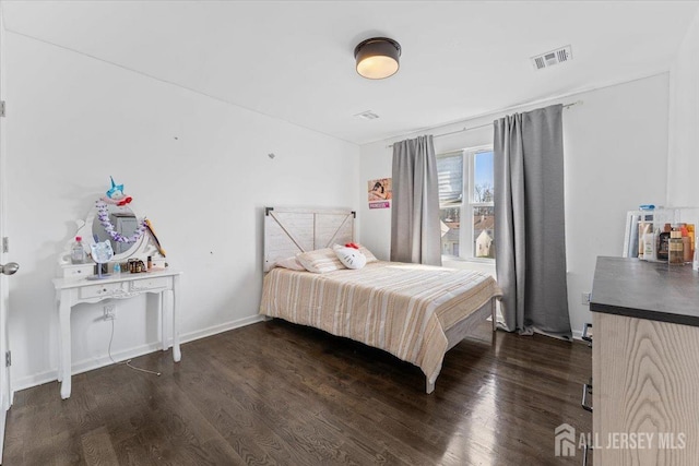 bedroom featuring wood finished floors and visible vents