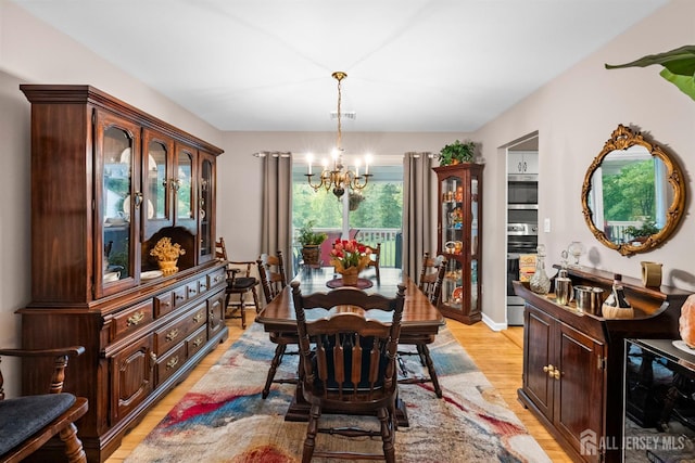 41 1st St, Franklin Twsp, NJ 08873 - dining space with a chandelier, light wood-style flooring, and beverage cooler