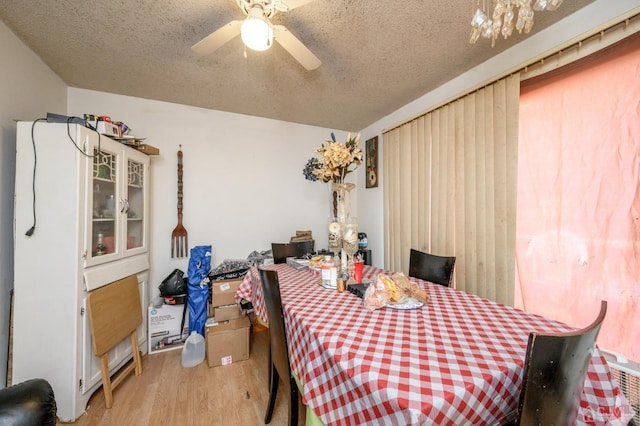 dining area featuring ceiling fan, wood finished floors, and a textured ceiling