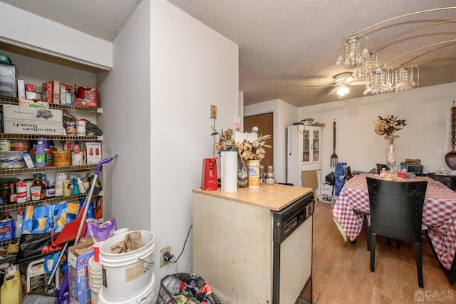 kitchen with dishwasher, wood finished floors, and a textured ceiling