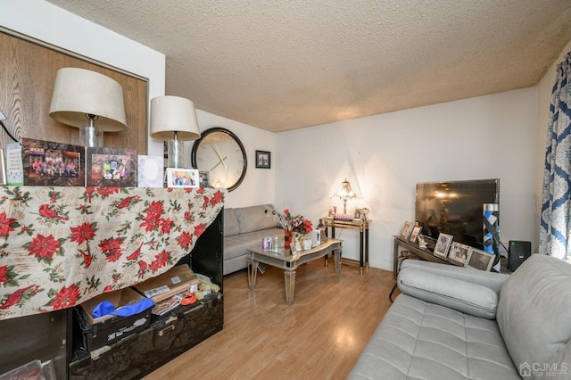 living area with a textured ceiling and wood finished floors