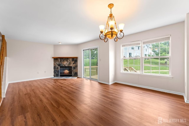 26 Allison Ct, South Brunswick, NJ 08852 - unfurnished living room featuring wood finished floors, a chandelier, a stone fireplace, and baseboards