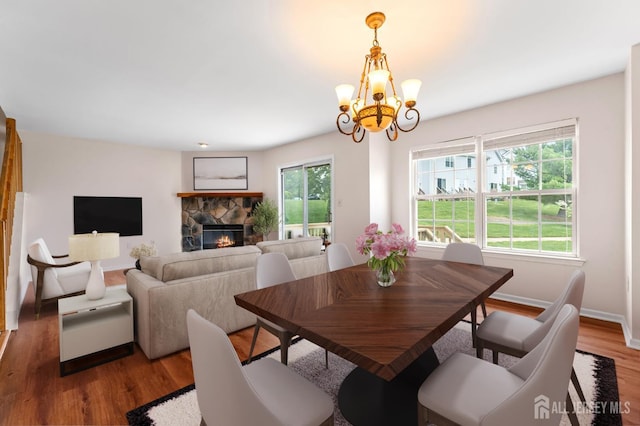 26 Allison Ct, South Brunswick, NJ 08852 - dining space with a chandelier, a stone fireplace, wood finished floors, and baseboards