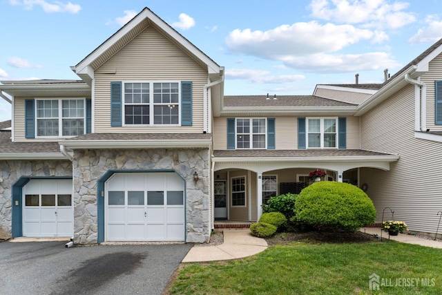 26 Allison Ct, South Brunswick, NJ 08852 - townhome / multi-family property with stone siding, driveway, a garage, roof with shingles, and covered porch