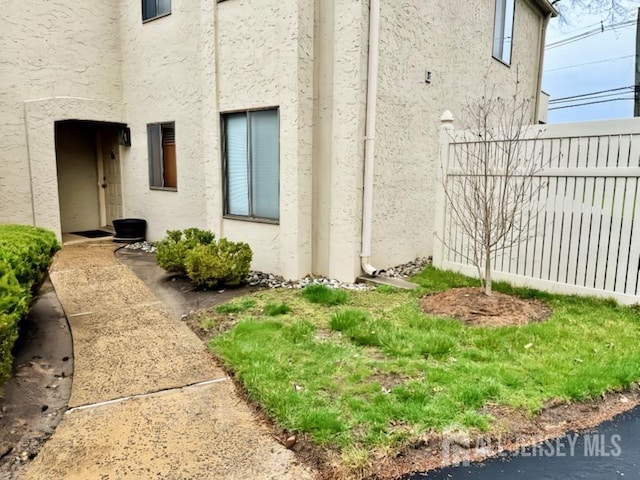 view of property exterior featuring stucco siding and fence
