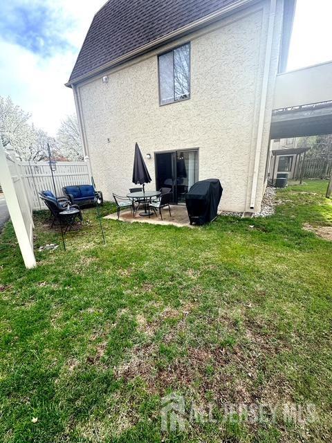 back of property with stucco siding, a patio area, and a shingled roof