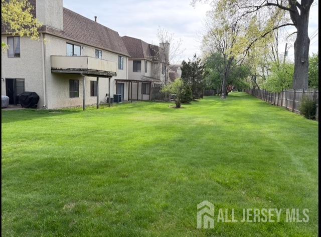 view of yard with a balcony and central AC unit