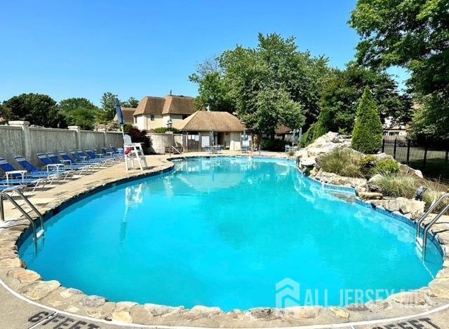 community pool with fence and a patio area