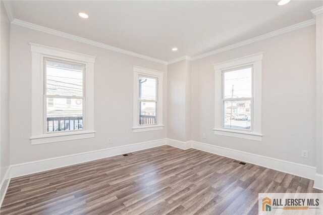 unfurnished room featuring hardwood / wood-style flooring and crown molding