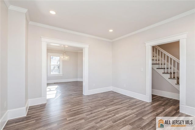 spare room featuring crown molding, a chandelier, and hardwood / wood-style floors