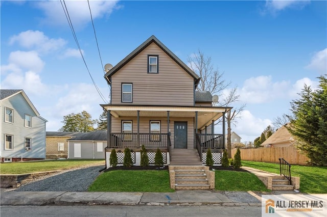 view of front of house featuring a front yard, a garage, a porch, and an outdoor structure