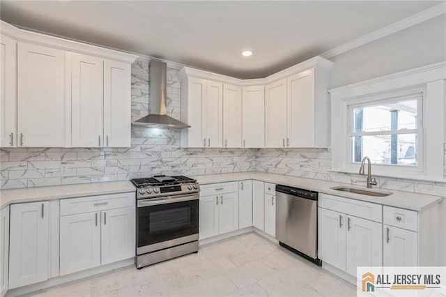 kitchen with white cabinetry, appliances with stainless steel finishes, wall chimney range hood, and sink