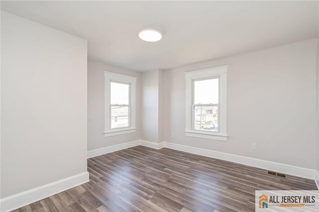 spare room with dark hardwood / wood-style floors