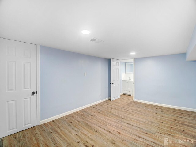 basement with light hardwood / wood-style flooring