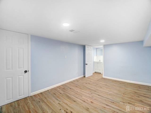 basement with light hardwood / wood-style floors