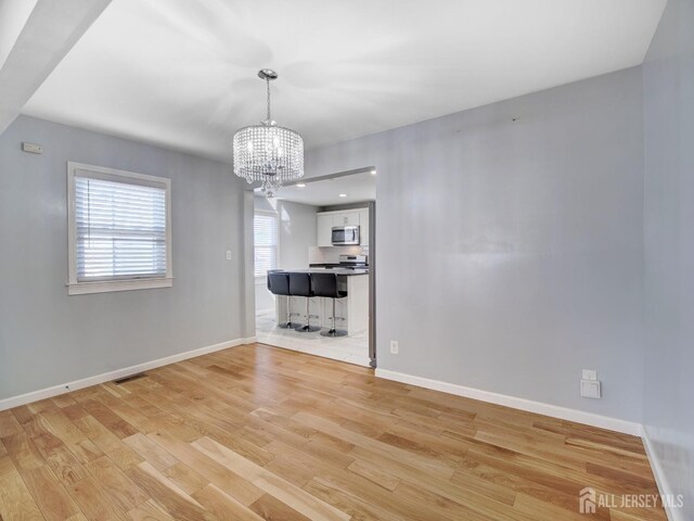 interior space with light hardwood / wood-style floors and a chandelier