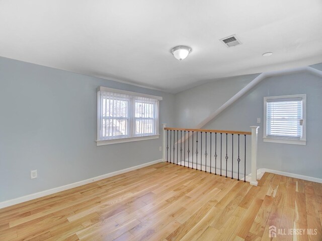 spare room with lofted ceiling and light hardwood / wood-style floors