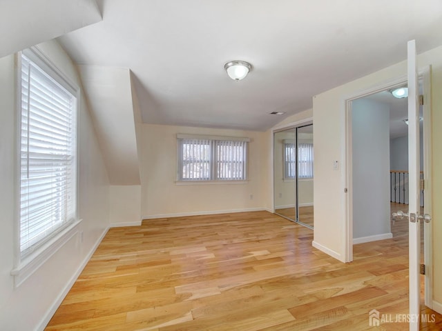 interior space with lofted ceiling and light hardwood / wood-style flooring