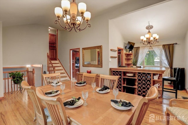 12 Euclid Rd, South Amboy, NJ 08879 - dining area with a chandelier, light wood finished floors, vaulted ceiling, and stairs