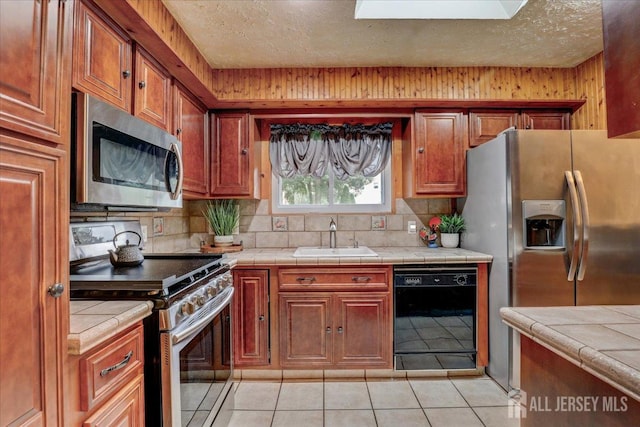 12 Euclid Rd, South Amboy, NJ 08879 - kitchen with appliances with stainless steel finishes, tile counters, light tile patterned floors, and a textured ceiling