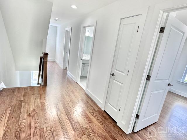 9 Melrose Ave, Sayreville, NJ 08879 - corridor with baseboards, wood finished floors, and an upstairs landing