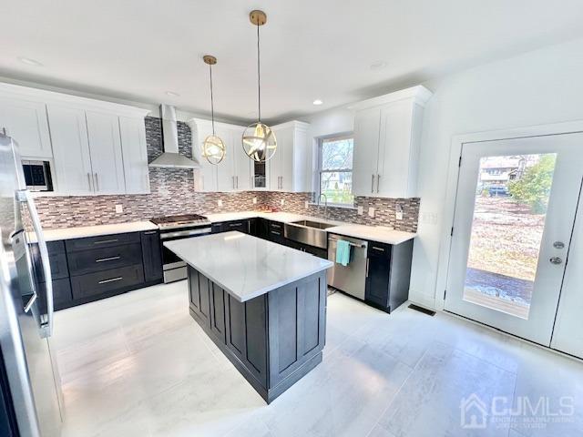 9 Melrose Ave, Sayreville, NJ 08879 - kitchen with white cabinets, a sink, wall chimney range hood, dark cabinets, and appliances with stainless steel finishes