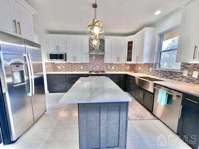 9 Melrose Ave, Sayreville, NJ 08879 - kitchen with decorative backsplash, appliances with stainless steel finishes, a sink, and white cabinetry