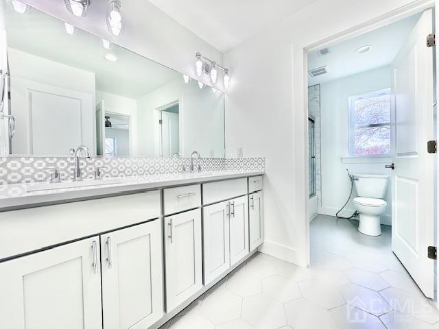 9 Melrose Ave, Sayreville, NJ 08879 - bathroom featuring toilet, visible vents, a sink, and double vanity