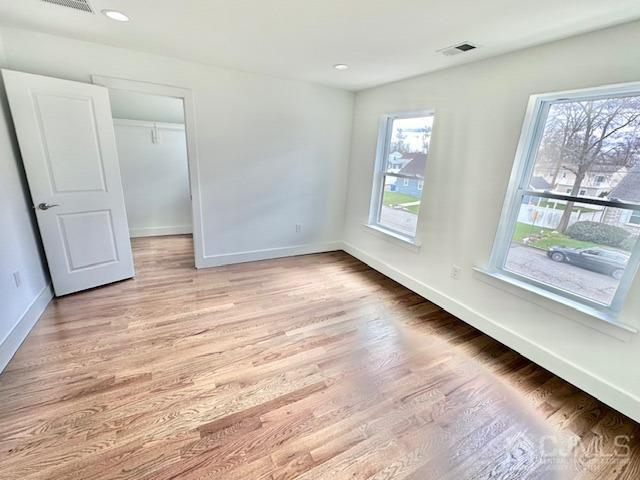 9 Melrose Ave, Sayreville, NJ 08879 - unfurnished bedroom featuring recessed lighting, a spacious closet, visible vents, light wood-style floors, and baseboards